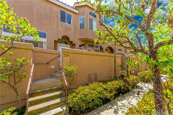 Front view of a multi-story house with stairs leading to the entrance.