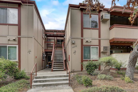 Front view of a two-story apartment building with external stairway.