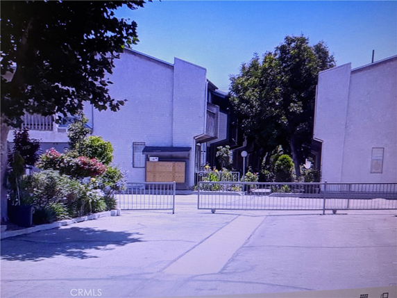 Front view of a multi-story building with a gated entrance.