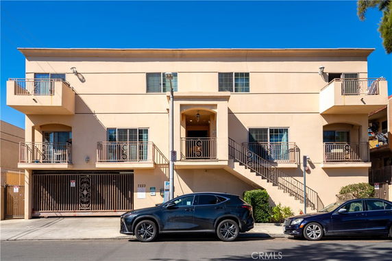 Front view of a multi-story apartment building with balconies.