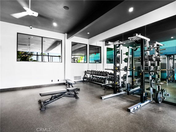Interior view of a gym area with weights and exercise equipment.