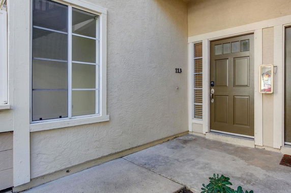 Front view of a house with a window and a single brown door.