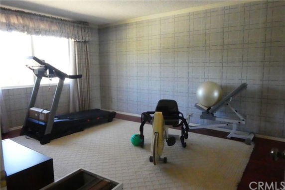 Room with exercise equipment including a treadmill and a stationary bike.