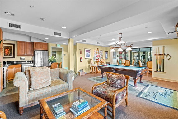 Recreation area with seating and a pool table inside a clubhouse.