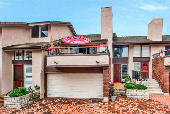 Front view of a townhouse with a double garage and small balcony.