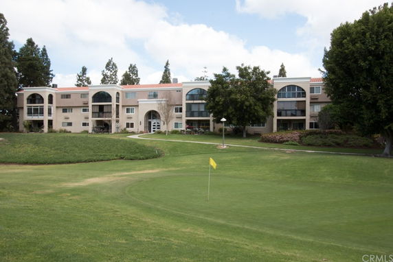 Front view of a multi-story residential building with arched windows and balconies.