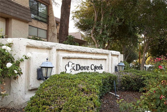 Front view of a building with white stucco walls and lamp fixtures.