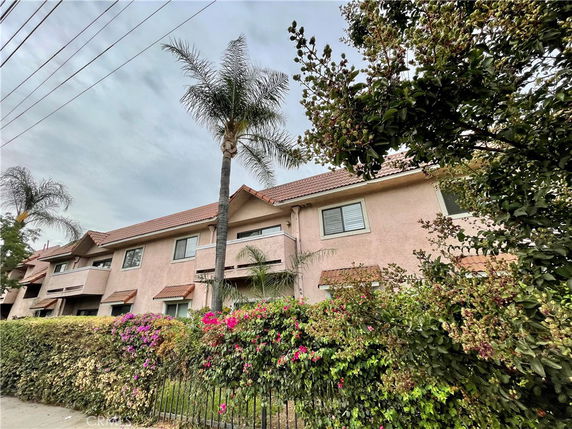 Front view of a two-story residential building with a sloped roof and multiple windows.