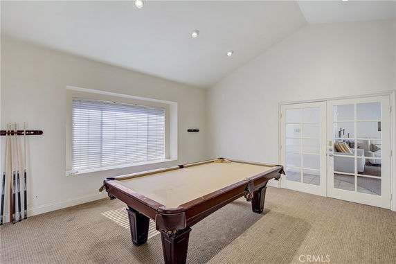 Room with a pool table and a large window.