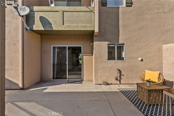 Front view of a house with a patio area and sliding glass door.
