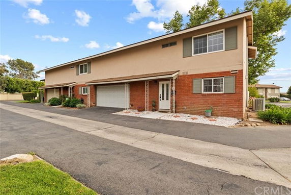 Front view of a two-story townhouse with a garage and entrance.