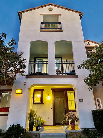 Front view of a multi-story house with balconies and a main entrance.