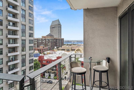 View from a balcony overlooking city buildings and distant waters.