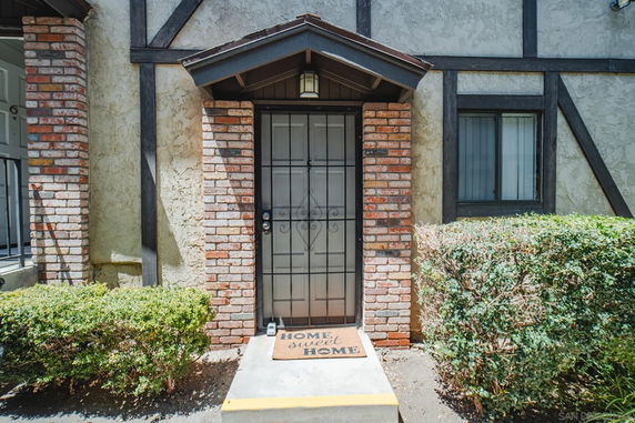Front view of a house entrance with brick and stucco exterior.