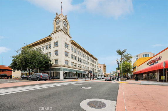 Front view of a multi-story building with a clock tower at the corner.