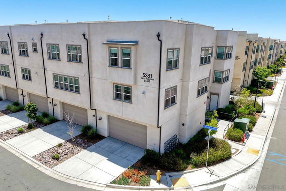 Front view of a multi-story residential building with multiple garage doors.