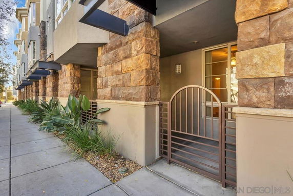 Front view of a building with stone cladding and metal gate entrance.