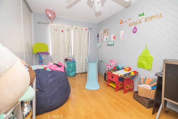 Indoor play area with toys, a slide, and decorative wall art for children.