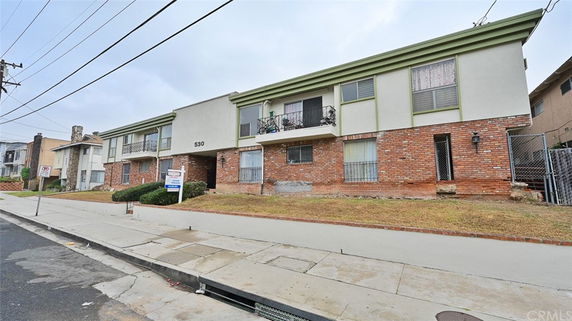Front view of a multi-story residential building with brick and stucco facade.