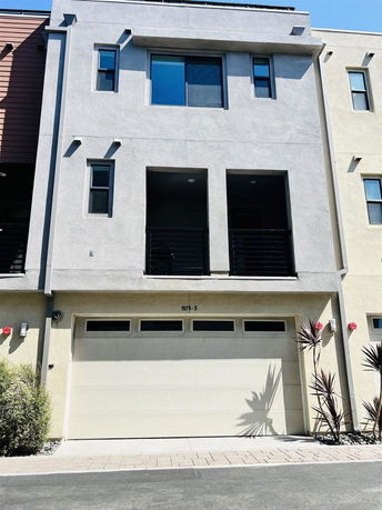 Front view of a multi-story house with a garage and balcony.