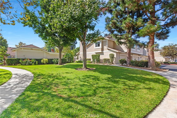 Front view of a house with a well-maintained lawn and trees.