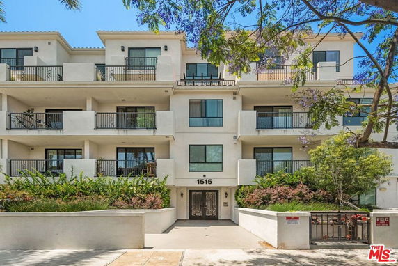 Front view of a multi-story apartment building with balconies.