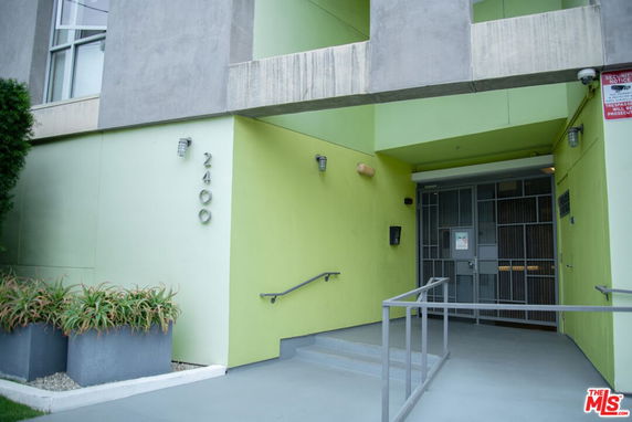 Front view of a building entrance with green walls and modern design.