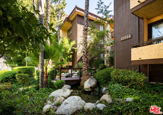 Front view of a multi-story building with wooden exterior and balconies.