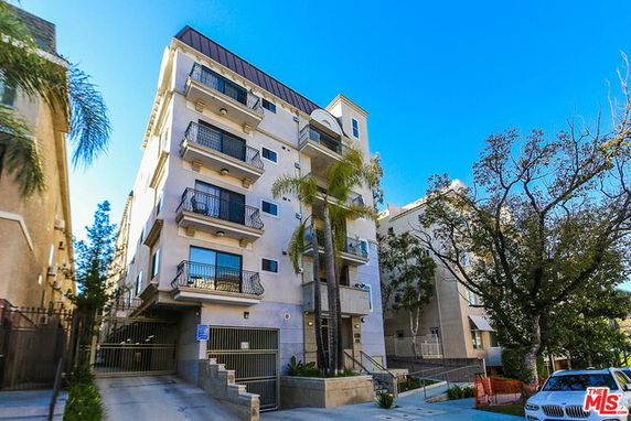 Front view of a multi-story apartment building with balconies.