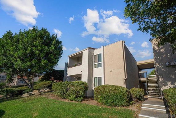 Front view of a two-story apartment building with a staircase and balcony.