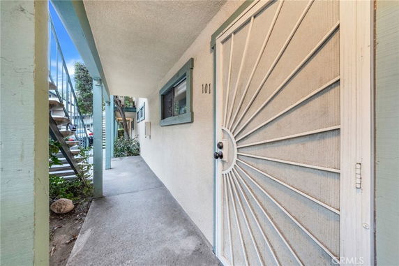 Front view of an apartment entrance with metal security door and exterior staircase.