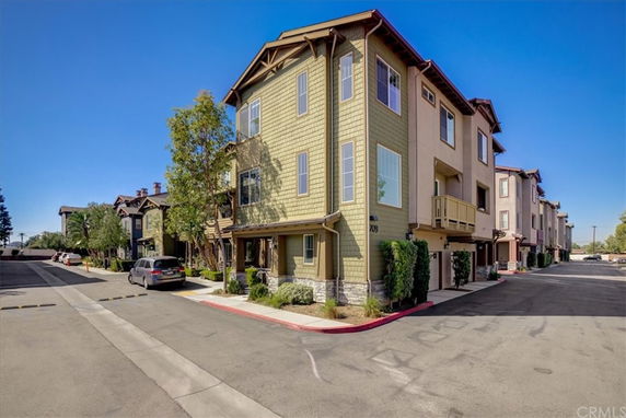 Front view of a multi-story townhouse with stone and siding exterior.