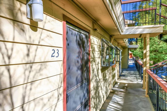 Exterior view of an apartment walkway with railing and unit number 23.