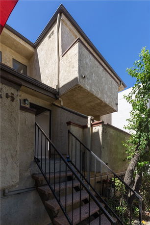 Front view of a two-story house with external staircase.