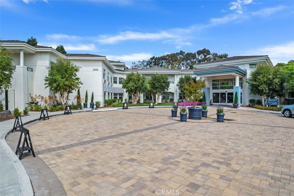 Front view of a large multi-story building with a paved entrance area and landscaping.