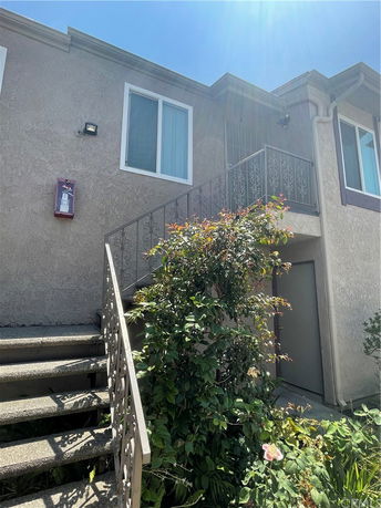 Front view of a two-story building with an external staircase.