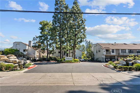 Front view of a residential complex with multiple two-story buildings and a driveway entrance.
