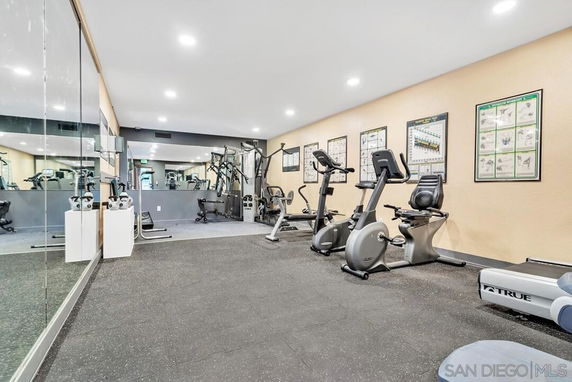 Interior view of a gym with exercise equipment such as stationary bikes and weight machines.