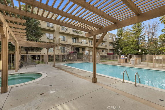 Outdoor swimming pool area with surrounding apartment building.