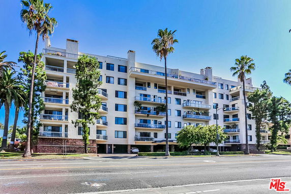 Front view of a multi-story residential building with balconies.