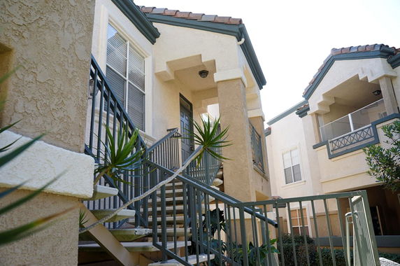 Front view of a multi-story apartment building with external staircases.