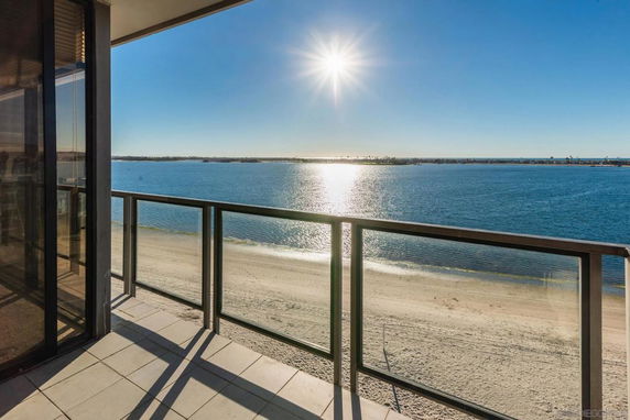 Panoramic view from a balcony overlooking a beach and ocean.