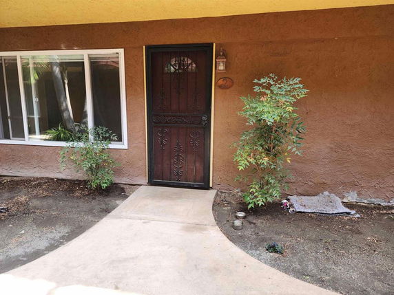 Front view of a house with a single door and window.