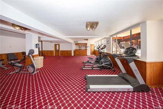 Indoor gym area with treadmills, exercise bikes, and red carpet flooring.