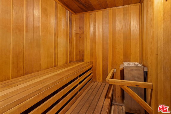 Interior view of a wooden sauna with benches and a heater.