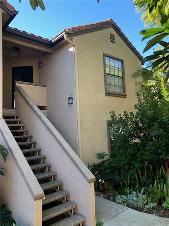 Front view of a house with external stairs and a single window.