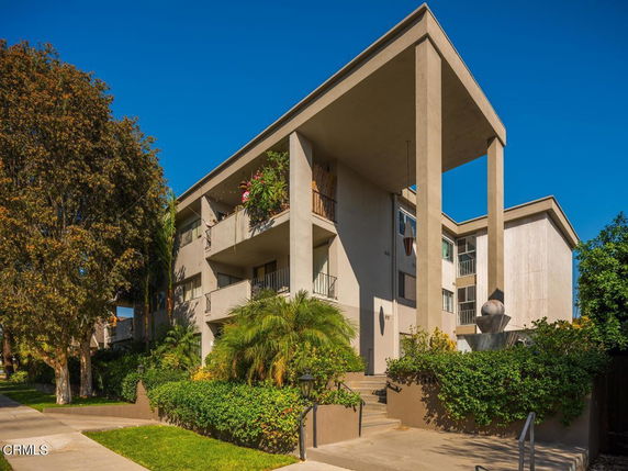Front view of a multi-story building with balconies and large columns.
