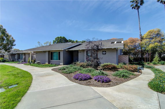 Front view of a single-story house with a sloped roof and landscaped garden.