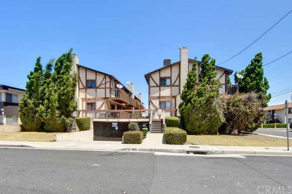 Front view of two adjacent townhouses with a shared driveway and garage entrance.