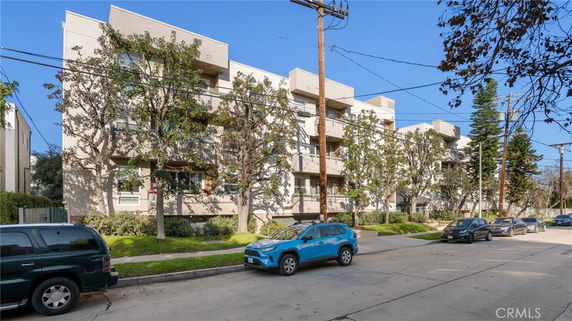 Front view of a multi-story apartment building with balconies.